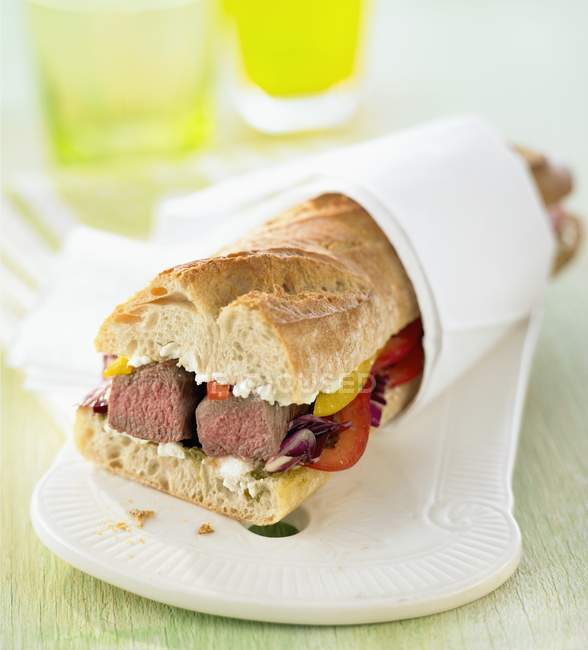 Meat and vegetables in baguette — Stock Photo