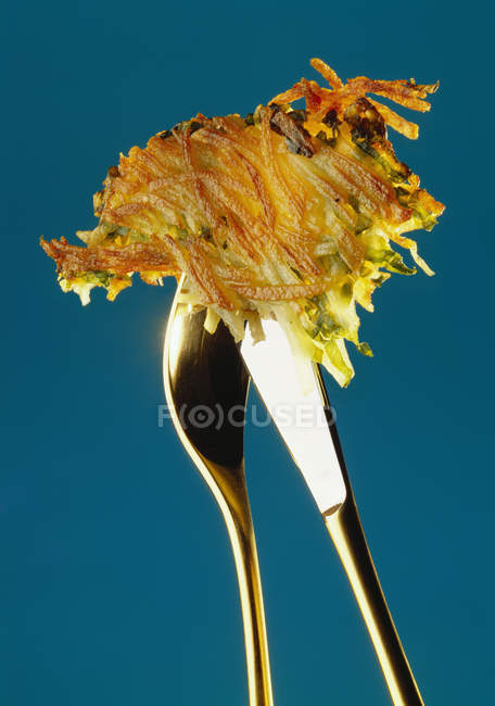 Potato rosti on cutlery — Stock Photo