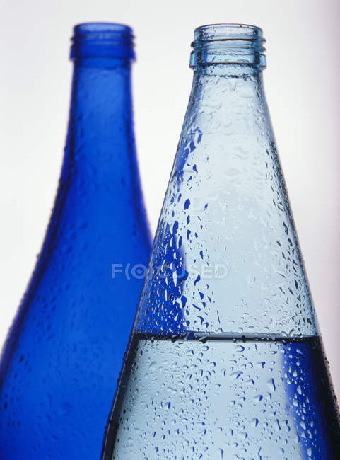 Вид крупним планом на дві пляшки блакитної води — стокове фото