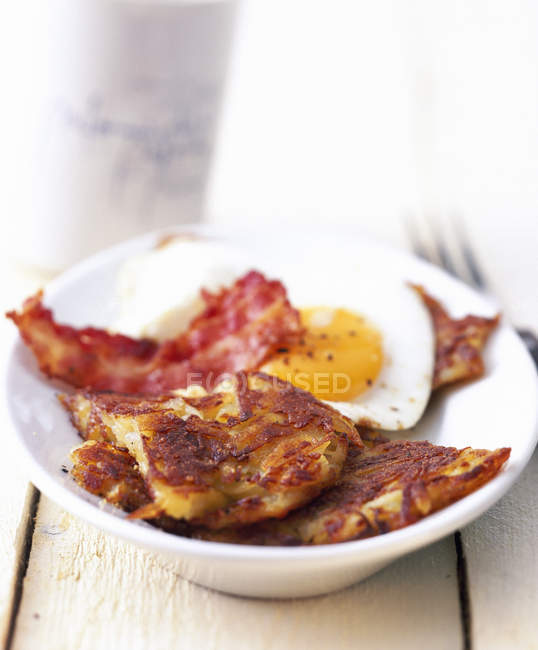 Potato pancakes with fried egg and bacon — Stock Photo