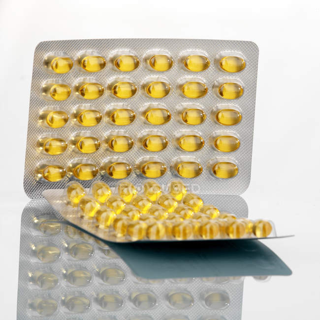 Closeup view of two packagings with yellow capsules of fish fat — Stock Photo