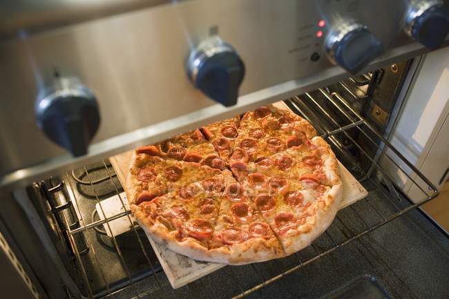 Pepperoni pizza in oven — Stock Photo