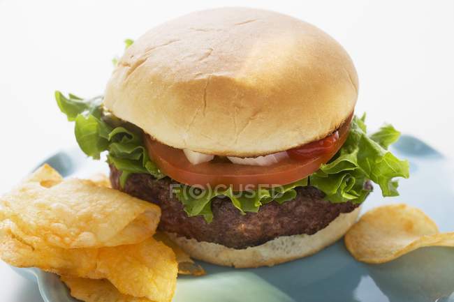 Hamburger with tomato and crisps — Stock Photo