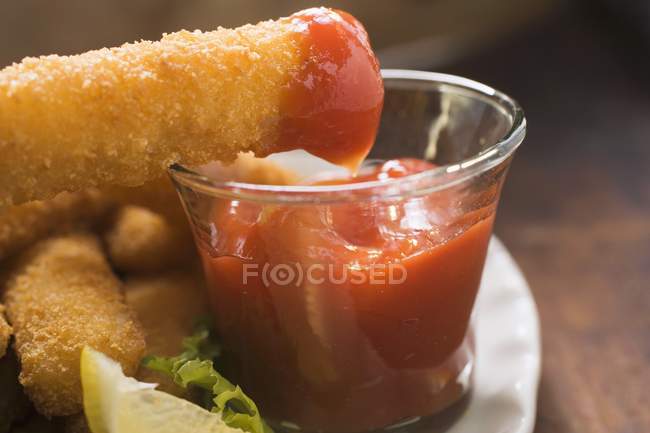 Рыбный палец с кетчупом — стоковое фото