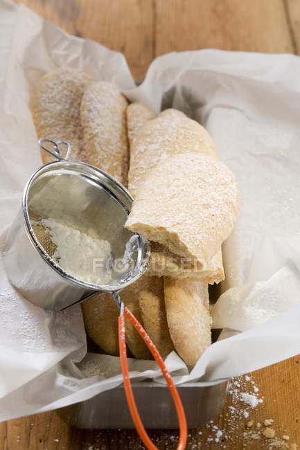 Closeup view of sponge fingers with icing sugar — Stock Photo