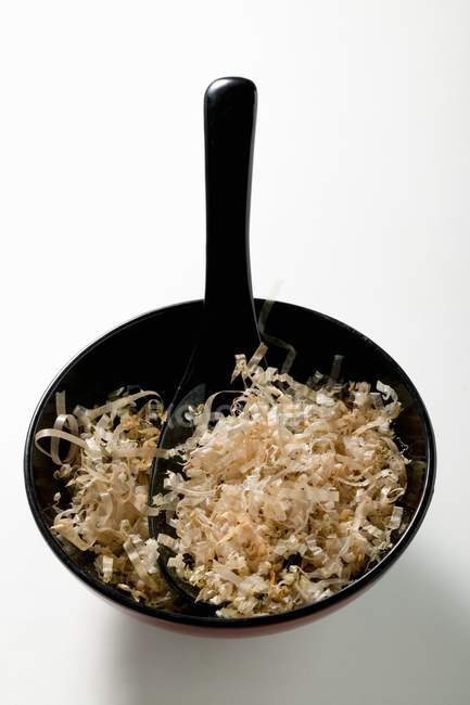 Closeup view of Bonito flakes in bowl with spoon — Stock Photo