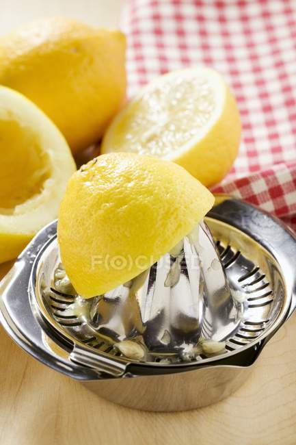 Limones con exprimidor de cítricos - foto de stock
