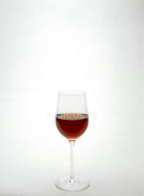Заполненный высокий красный бокал вина — стоковое фото