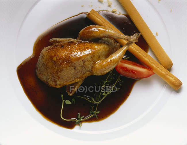 Quail with balsamic sauce and bread sticks — Stock Photo