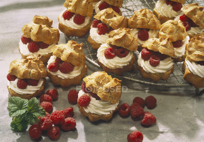 Closeup view of cream puffs with raspberries — Stock Photo