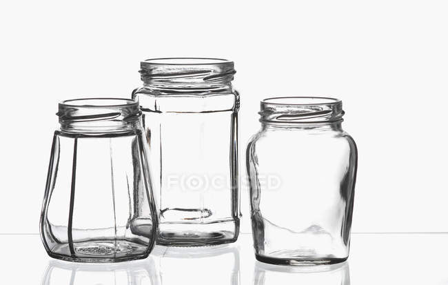 Trois bocaux vides sur une feuille de verre — Photo de stock
