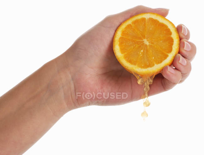 Hand squeezing orange — Stock Photo