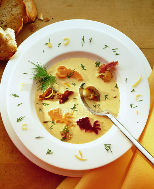 Bouillabaisse con pescado vegetal en plato blanco con cuchara - foto de stock