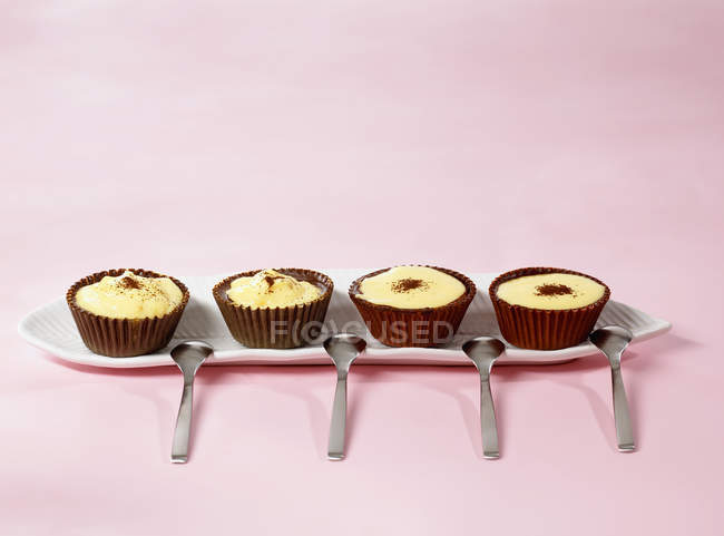 Vista de cerca de cuatro Sundaes chocolate con vainilla blancmange - foto de stock