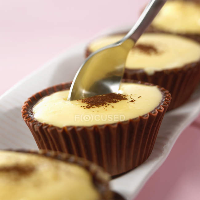 Vanilla Blancmange in chocolate cases with spoon — Stock Photo