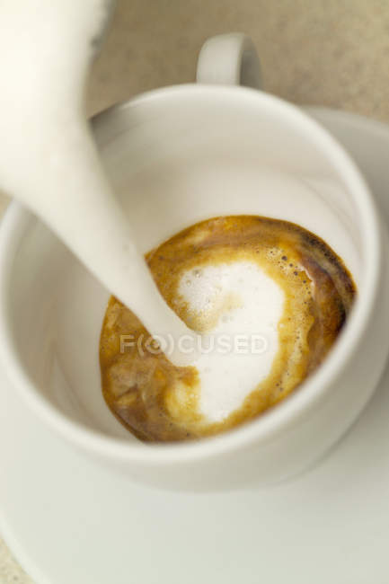 Fare un cappuccino con il latte — Foto stock