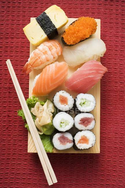 Sushi surtido en el tablero de sushi - foto de stock