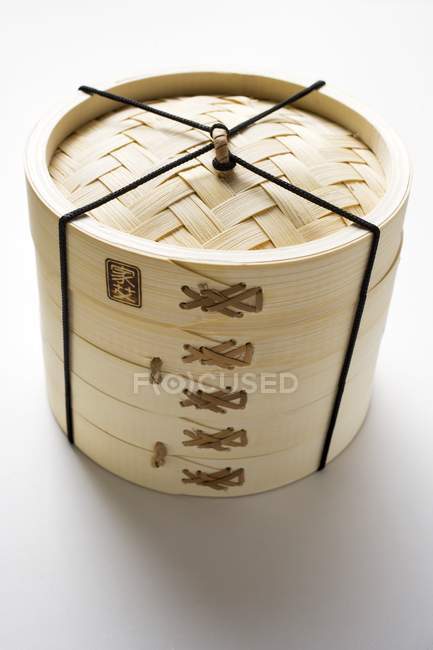 Elevated view of tied Asian bamboo steamer on white surface — Stock Photo