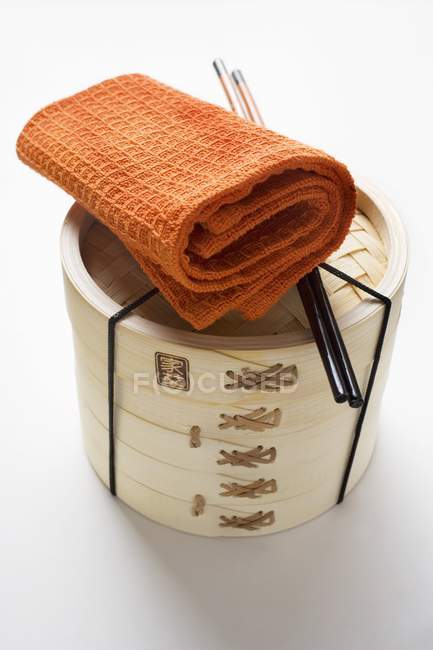 Towel, chopsticks and bamboo steamer — Stock Photo