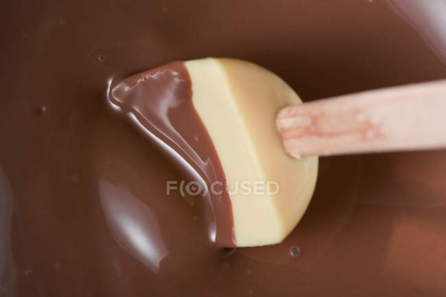 Крупный план расплавленного шоколада со смешивающей ложкой — стоковое фото