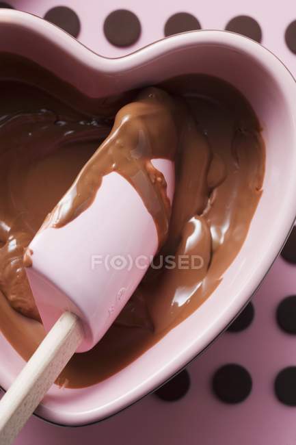 Vista close-up de chocolate derretido com colher de mistura — Fotografia de Stock