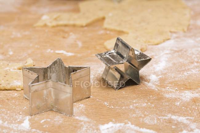 Closeup view of star-shaped biscuit cutters and biscuit dough — Stock Photo