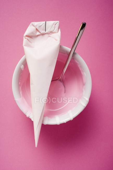 Вид зверху на трубний мішок з рожевим глазур'ю і ложкою — стокове фото
