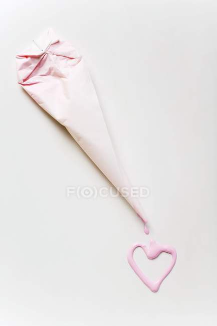 Top view of pink iced heart and a piping bag — Stock Photo