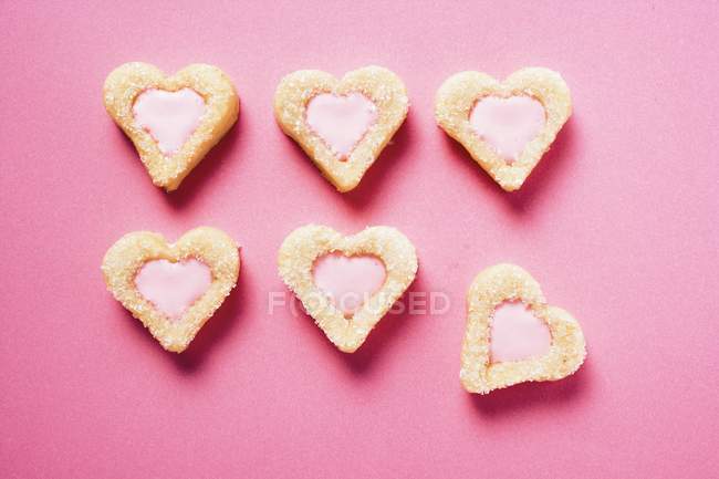 Galletas en forma de corazón con glaseado rosa - foto de stock