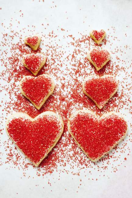 Galletas en forma de corazón con azúcar roja - foto de stock