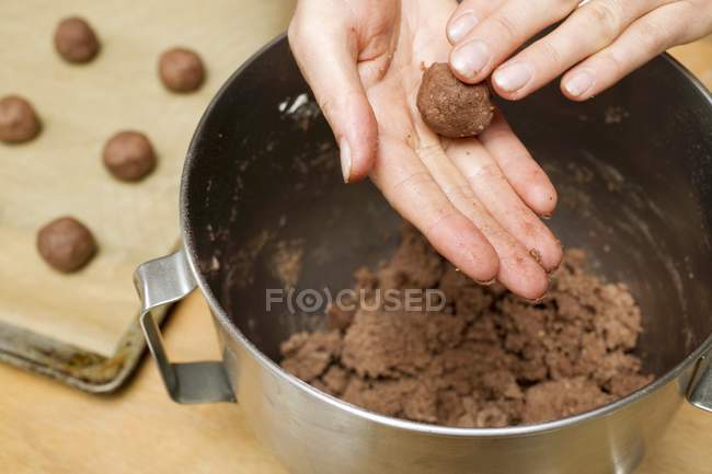 Cropped view of hands forming hazelnut dough to small balls — Stock Photo