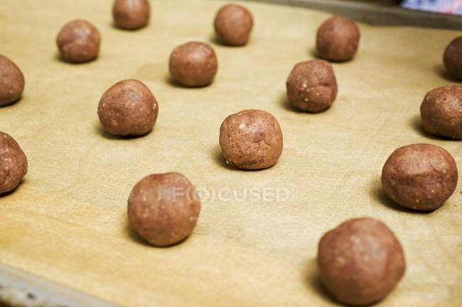 Vue rapprochée de boules de pâte à noisettes sur une plaque à pâtisserie — Photo de stock