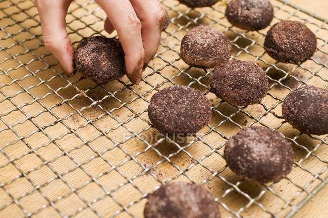 Mão humana colocando biscoitos de avelã — Fotografia de Stock