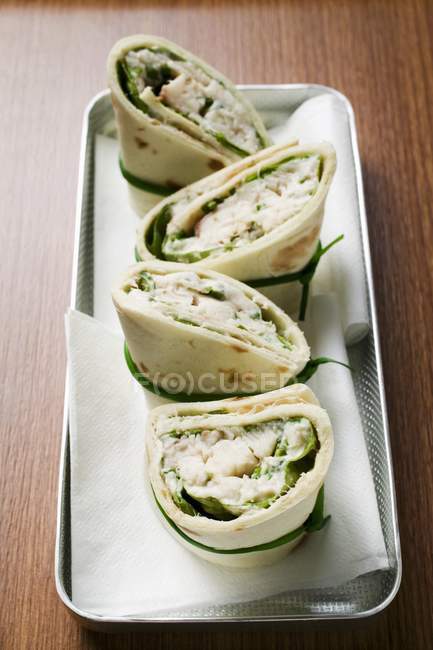 Closeup elevated view of four wraps with fish filling — Stock Photo