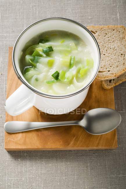 Leek cream soup with bread and spoon — Stock Photo