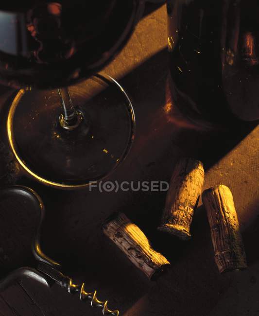 Still life with red wine, wine corks and corkscrew — Stock Photo