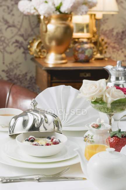 Vista close-up de mesa colocada com sobremesa com flores e suco — Fotografia de Stock
