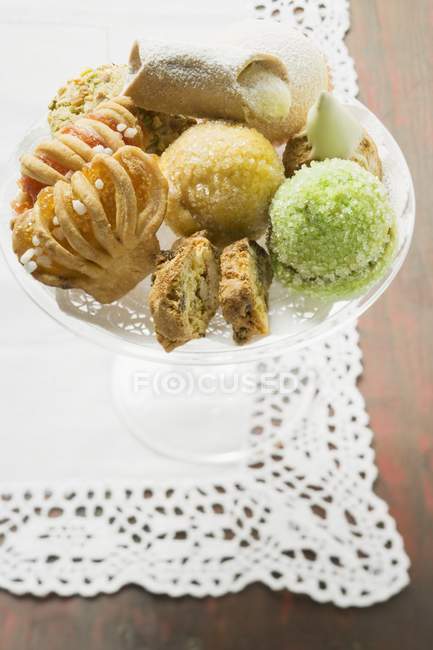 Vue rapprochée de petites pâtisseries assorties en verre — Photo de stock