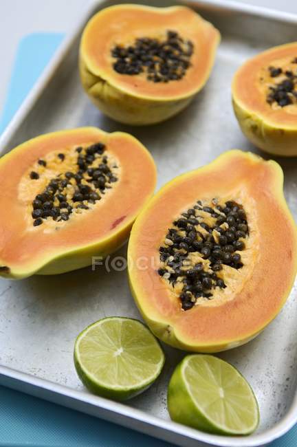 Halbierte Papayas und Limetten — Stockfoto