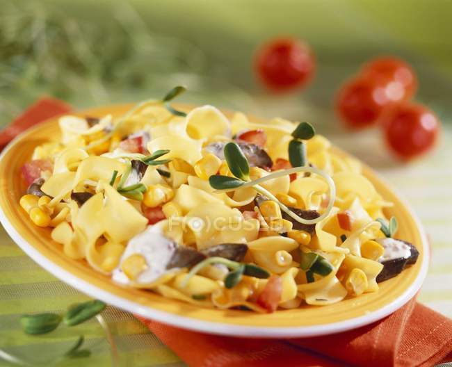 Ribbon pasta with sweetcorn and sprouts — Stock Photo