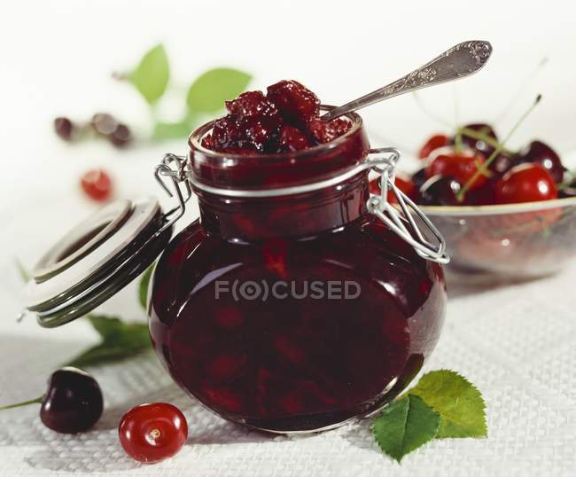 Closeup view of preserved cherries in glass jar — Stock Photo