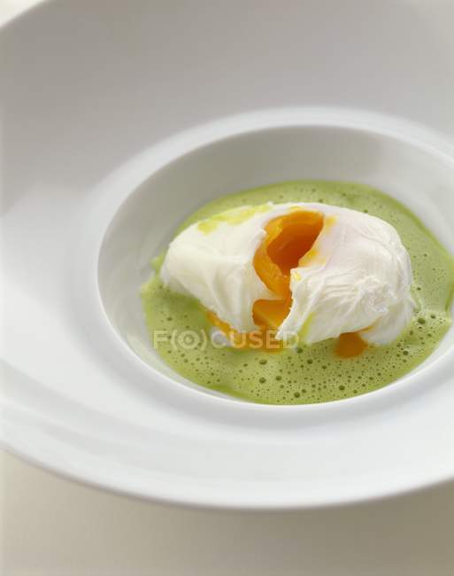Herb foam soup with poached egg — Stock Photo
