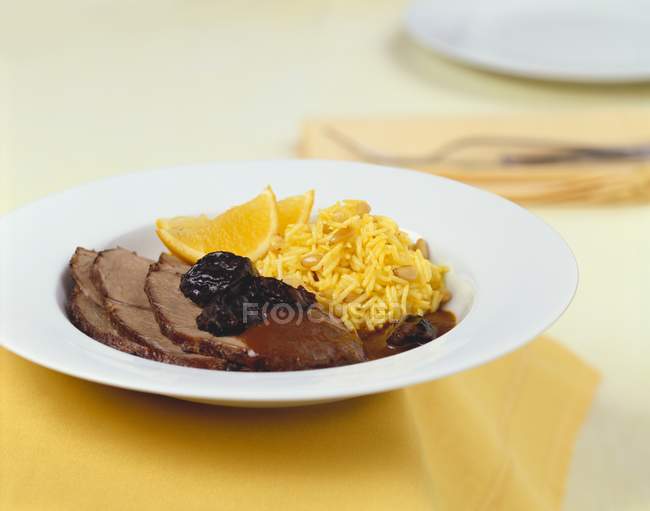 Cordeiro com molho de ameixa e arroz laranja — Fotografia de Stock