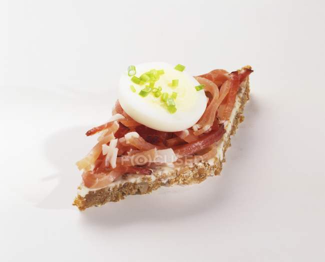 Bacon strips and slice of egg on wholegrain bread — Stock Photo