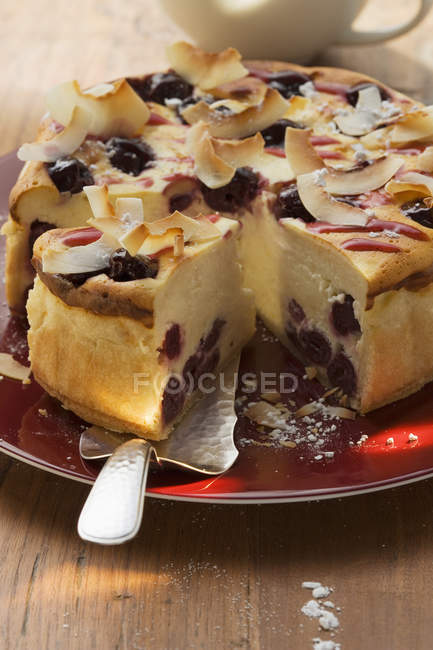 Cheesecake with cherries and coconut shavings — Stock Photo