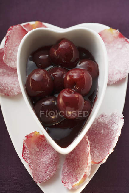 Cherry compote and rose petals — Stock Photo