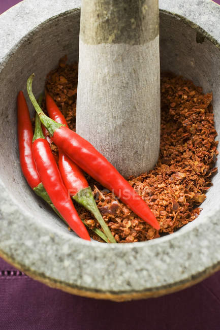 Peperoni e polvere di peperoncino in mortaio — Foto stock