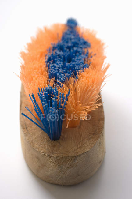 Nahaufnahme orangefarbener und blauer Holzpinsel auf weißer Oberfläche — Stockfoto