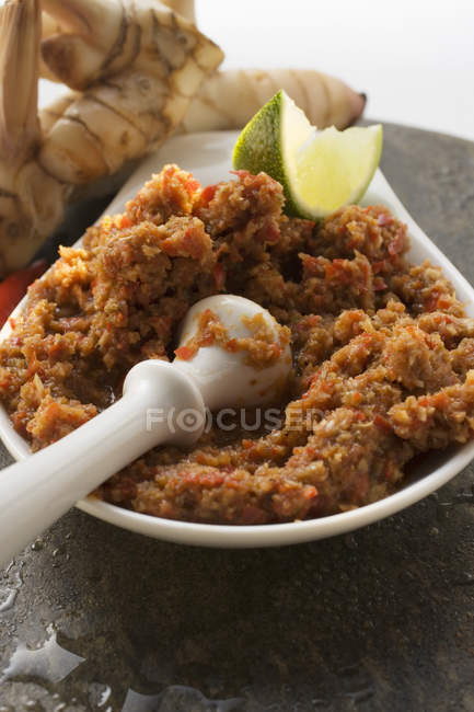 Chili paste with galanga on white plate with mortar — Stock Photo