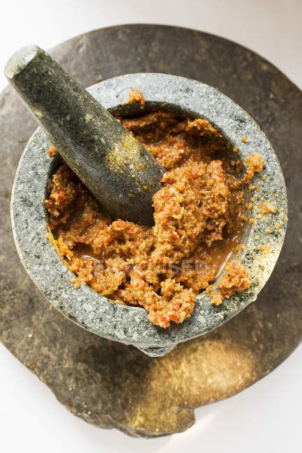 Chilipaste mit Galgant im Mörser auf weißem Hintergrund — Stockfoto
